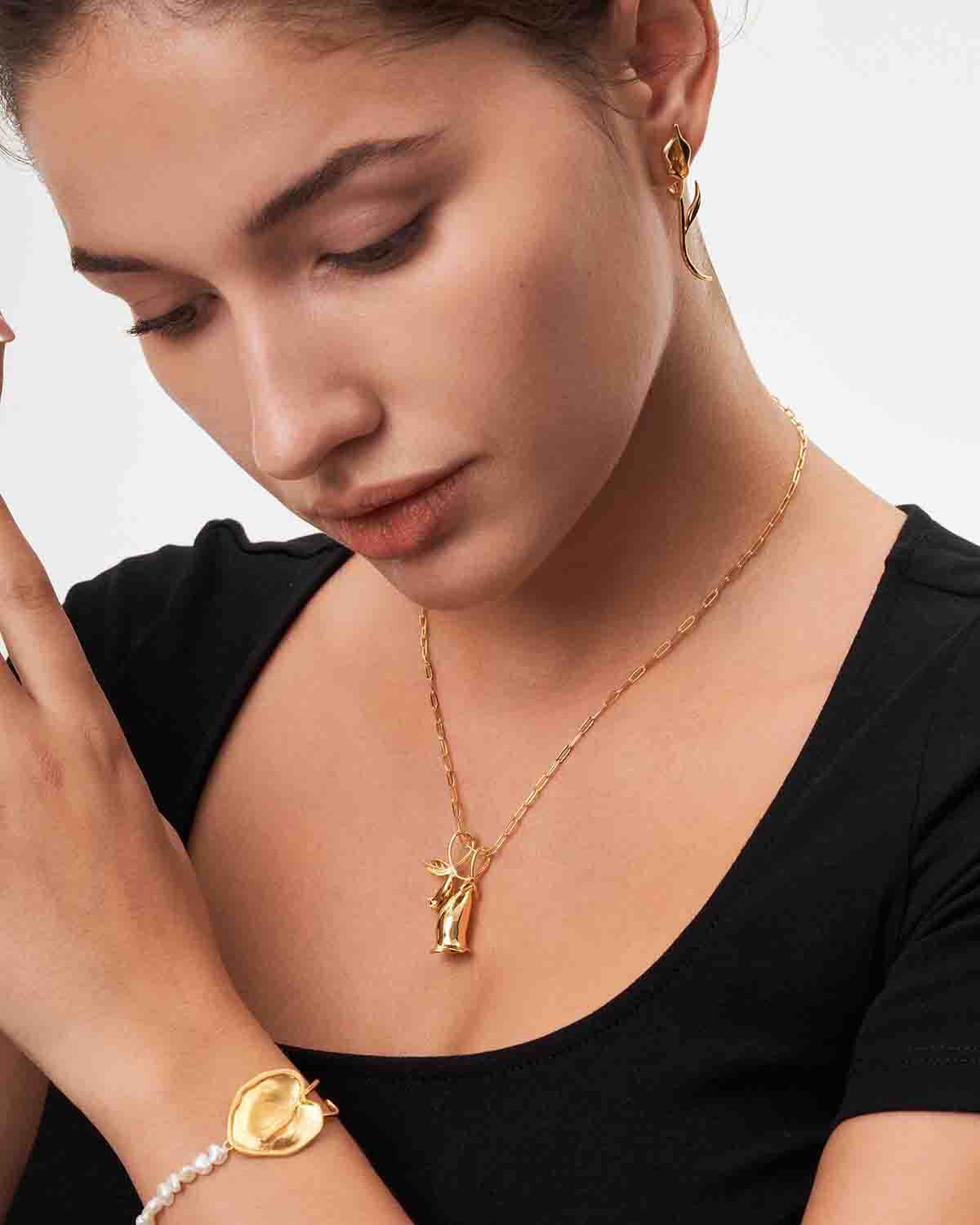 a woman wearing a black shirt and a gold bracelet