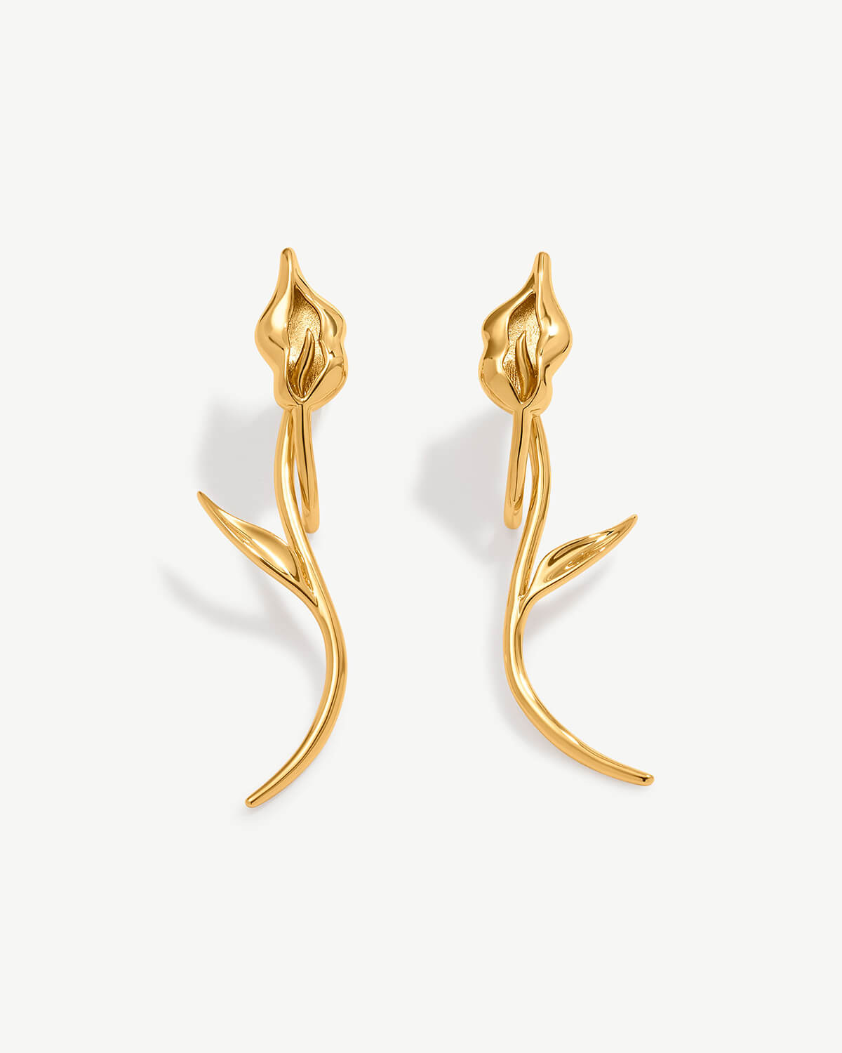 a pair of gold earrings with a flower design