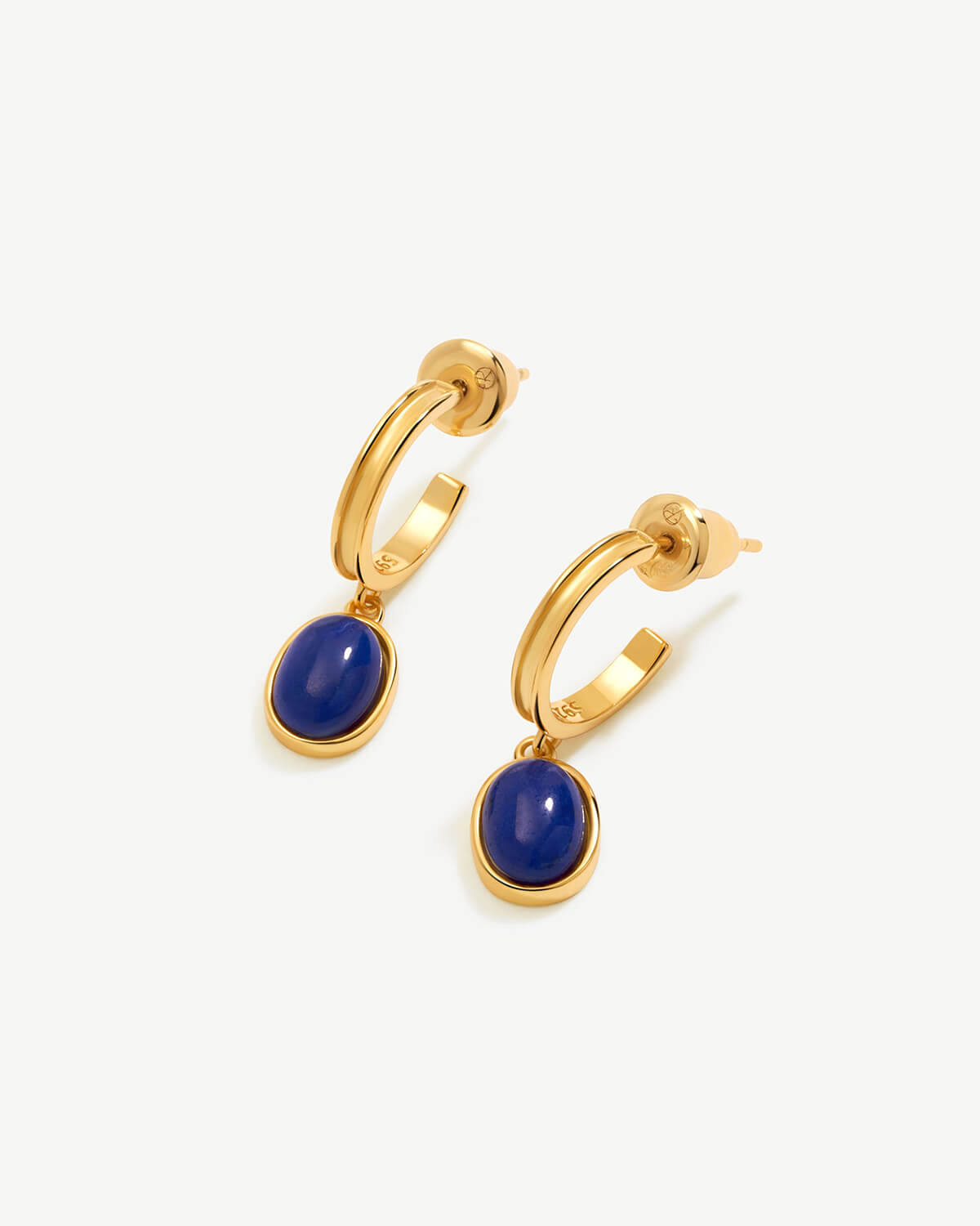 a pair of earrings with a blue stone