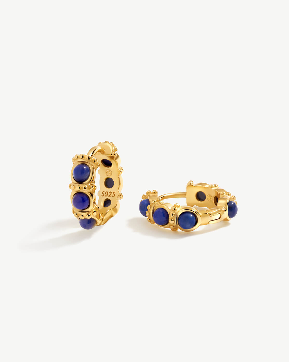 a pair of gold earrings with blue stones
