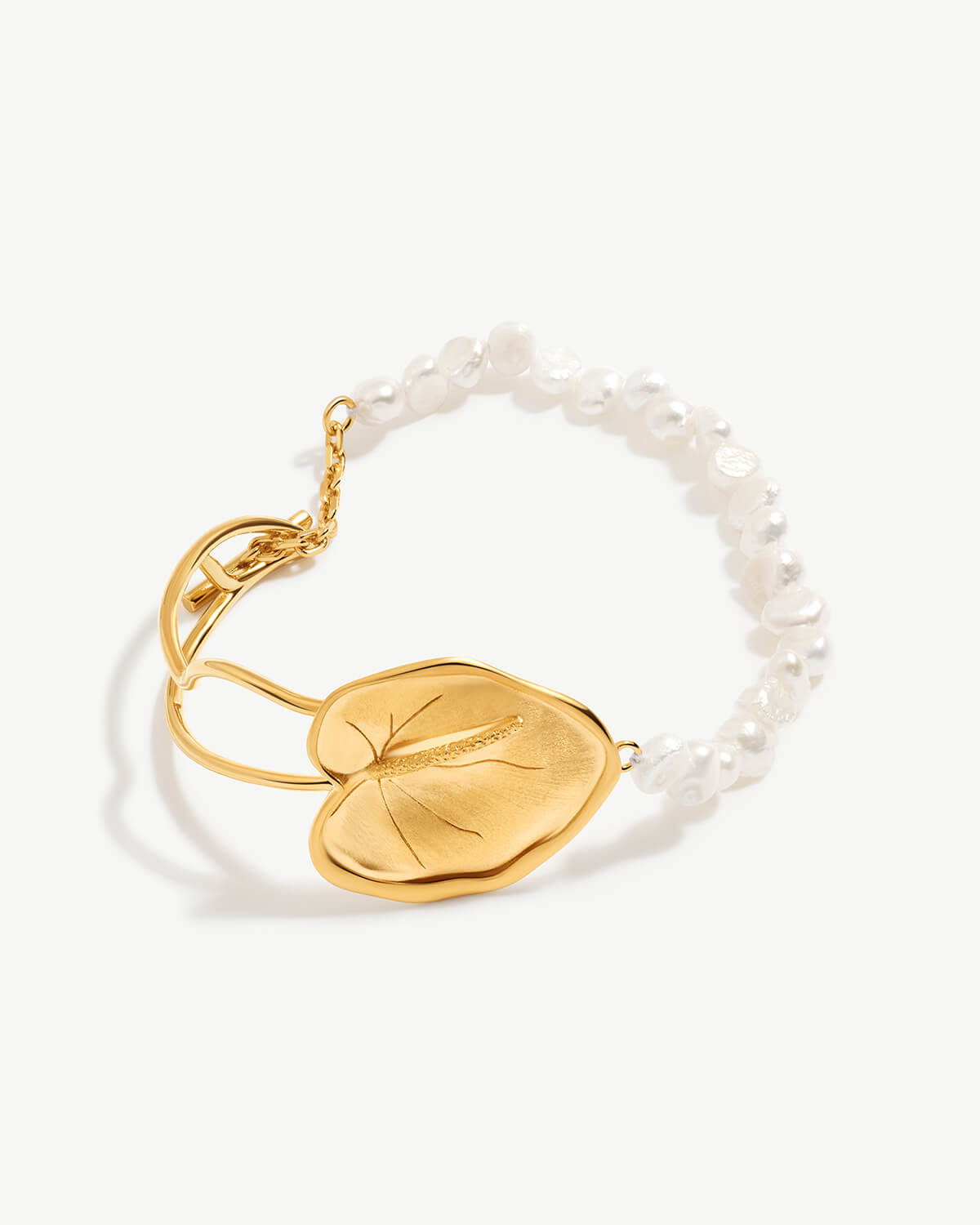 a pearl bracelet with a gold leaf charm